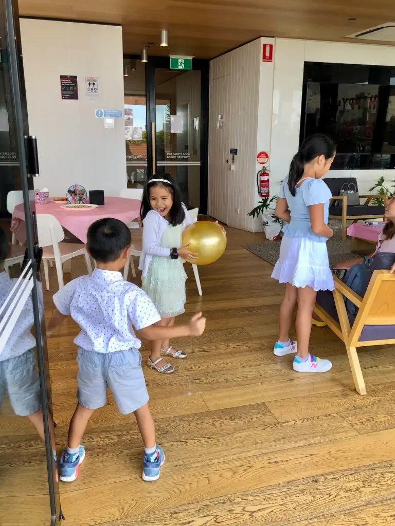 Boys and girls happily playing at a kids birthday party.
