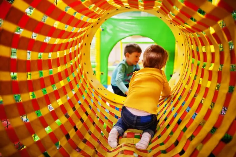 Kindergarten or preschool play room. Baby girl climbs