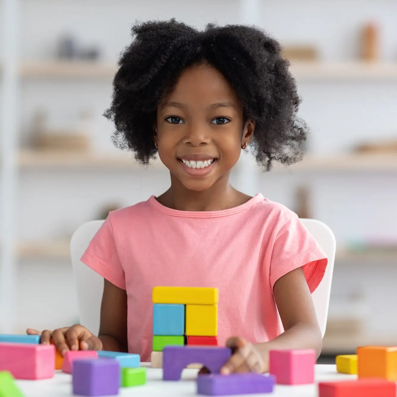 Portrait of cheerful adorable kid playing with wood blocks